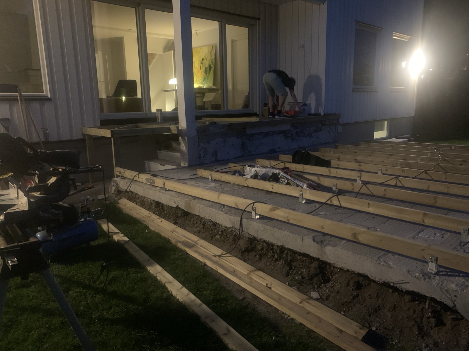 The stripped slab with the trench along its edge, and the frame starting to run out from the house.
