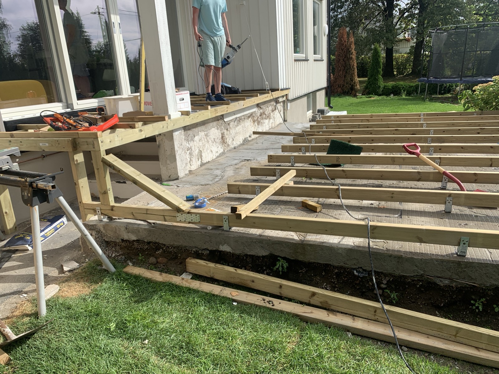 Both levels framed — the raised section against the house, the lower deck out over the slab.