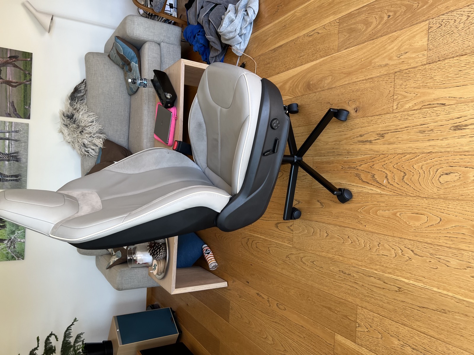 From the side, on the gas-spring column. The seat's factory switchgear still runs recline, height, tilt and lumbar; the welded adapter is underneath, hidden by the trim.